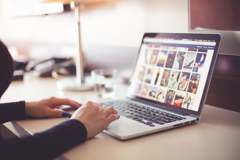 person typing on laptop, sitting at a table