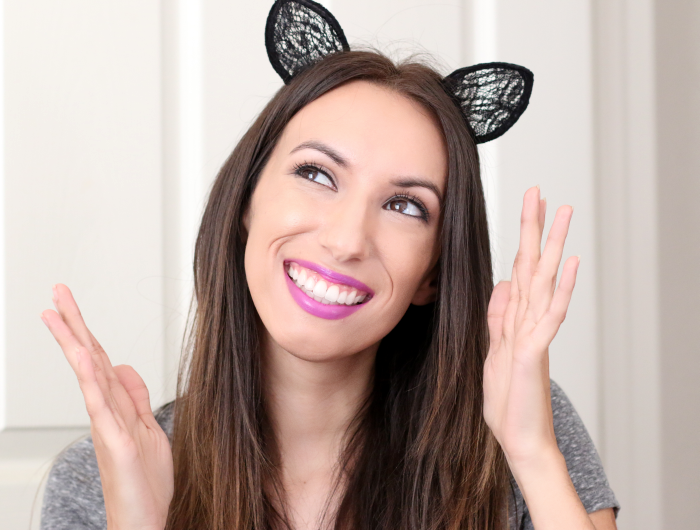 smiling girl with cat ears headband and purple lipstick