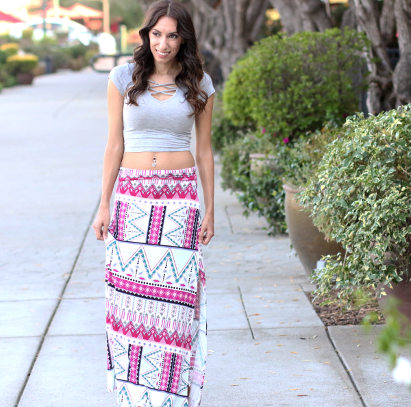 girl walking outside in aztec printed maxi skirt and crop top