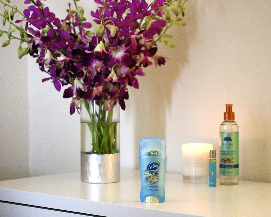 personal care items and a vase of purple flowers on a table