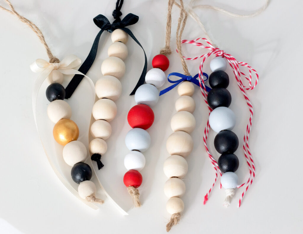 5 wood bead ornaments laying on table