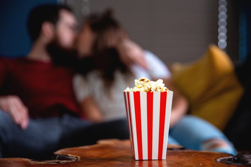 popcorn on table with couple kissing in the background