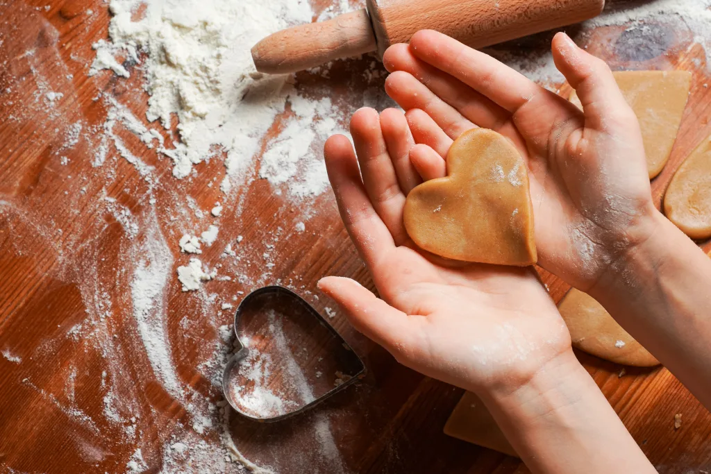 Hands holding heart-shaped dough